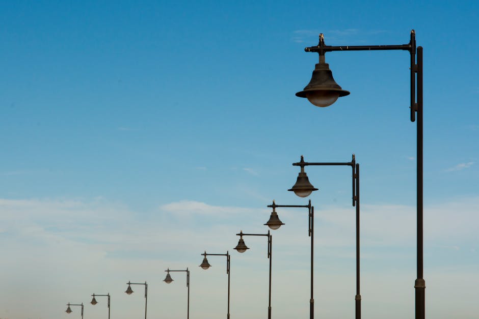A scenic view of vintage street lamps lined up against a bright blue sky.
